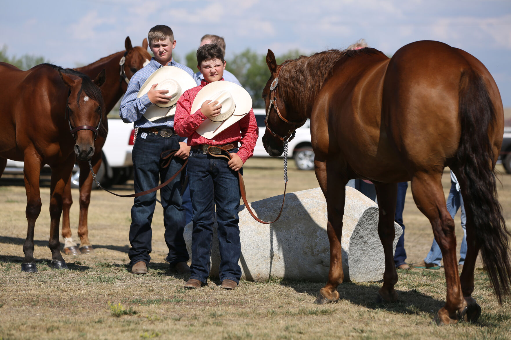 From left, James Foss, 13, and Ace Neville, 11, remove their hats